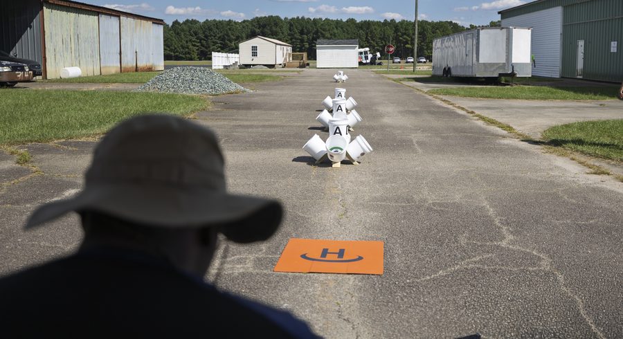 Operator flying an FPV proficiency course of gates and a landing pad